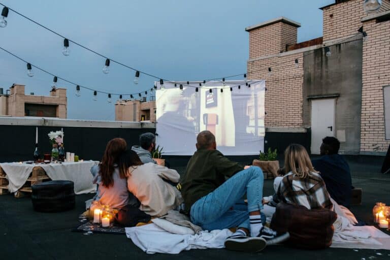 People relaxing on a rooftop lounge near a fire pit at dusk
