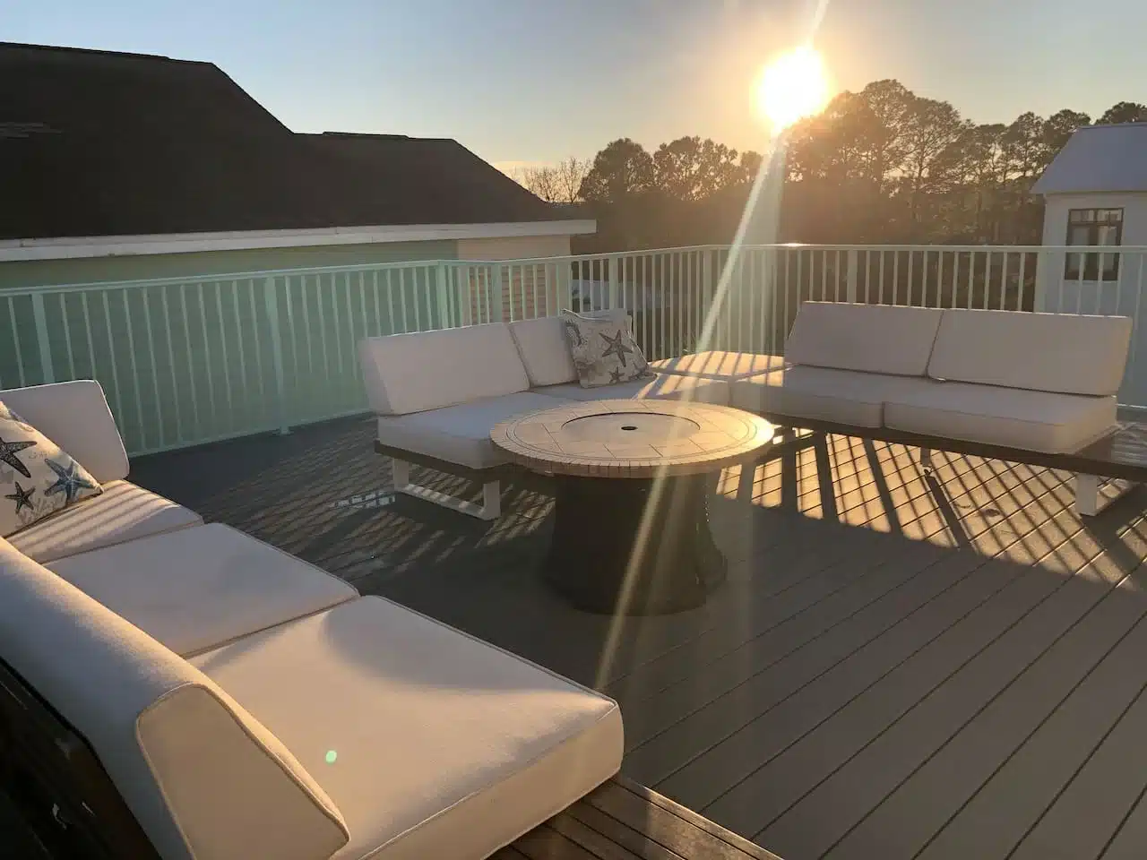 Luxury rooftop deck with lounge seating and fire table at sunset in Santa Rosa Beach, FL
