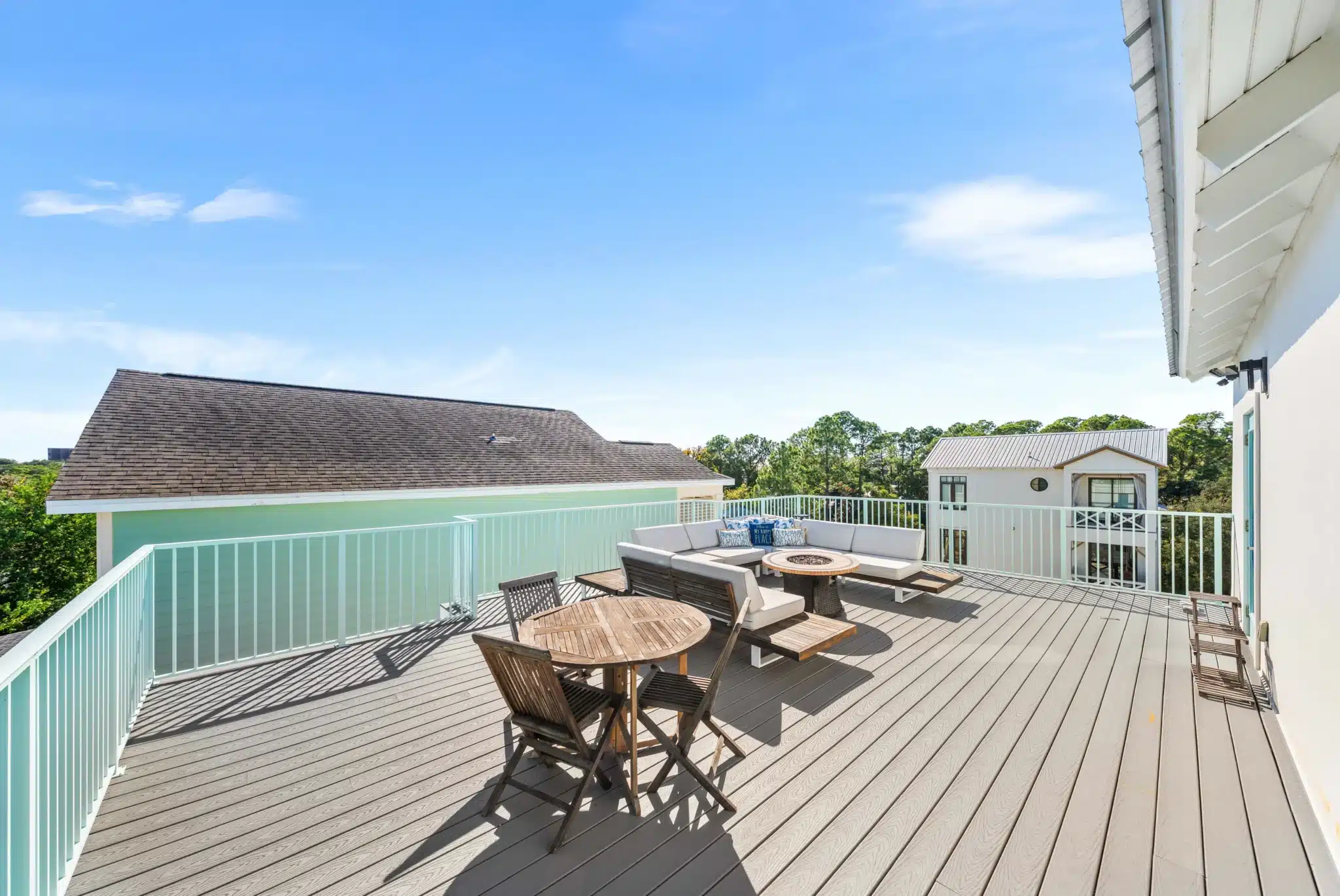Rooftop movie night space with lounge seating, fire table, and turquoise railing overlooking coastal views in Santa Rosa