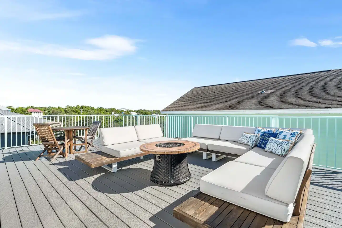 Rooftop deck with cream loungers and sofas around a fire table and coastal views, a rooftop movie night spot at our Blue